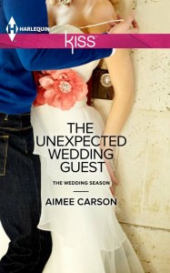 A bride caucasian bride is seen from the chest down, pressed against a wall by a man in a blue shirt and jeans.