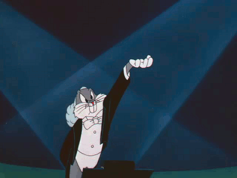 Animated gif of bugs bunny in a tux conducting an orchestra by holding his left arm up with his hand palm up and jiggling.
