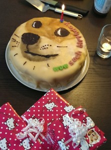 A birthday cake with the "doge" dog on it and the words "WOW SUCH BIRTHDAY"
