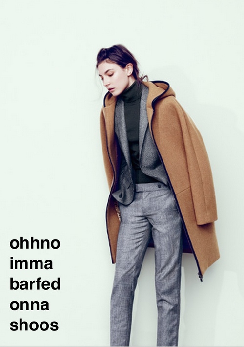 An image of a white woman in grey trousers, a black turtleneck and a grey blazer wears a camel coat on her shoulders like a cape. Her brown hair is slightly messy and she looks at the ground kind of glassy eyed. text reads: ohhno imma barfed onna shoos